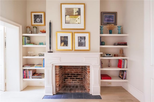 living area featuring hardwood / wood-style floors and built in shelves