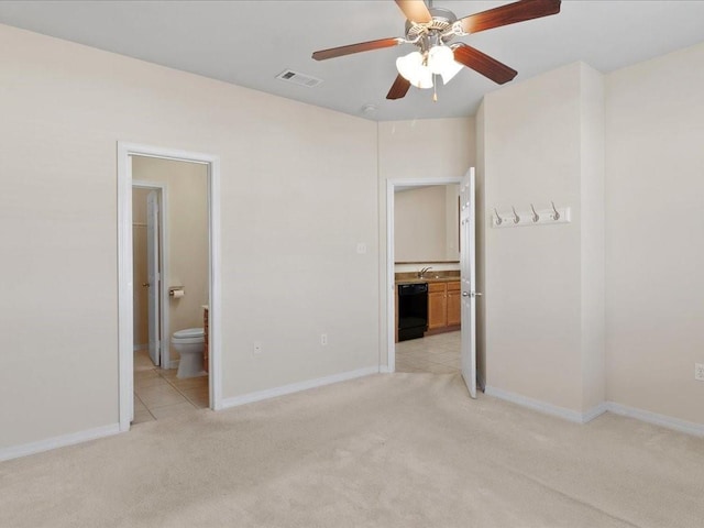 unfurnished bedroom with baseboards, connected bathroom, visible vents, and light colored carpet