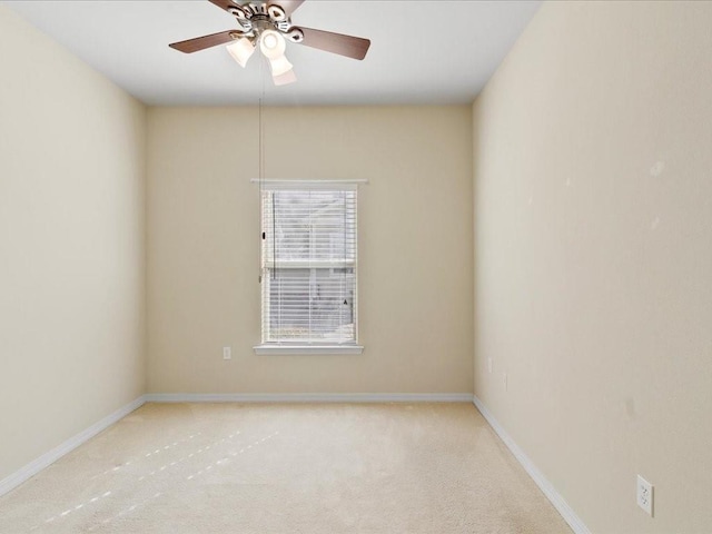 spare room featuring ceiling fan, carpet, and baseboards