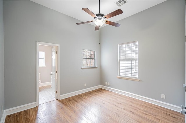 unfurnished bedroom with ensuite bathroom, ceiling fan, and light hardwood / wood-style flooring