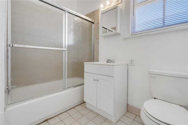 full bathroom featuring bath / shower combo with glass door, tile patterned floors, toilet, and vanity