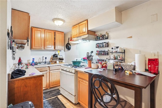 kitchen featuring sink, a textured ceiling, gas range gas stove, and light tile patterned floors