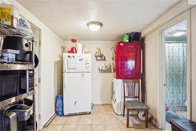 kitchen featuring light tile patterned floors, a textured ceiling, and white refrigerator