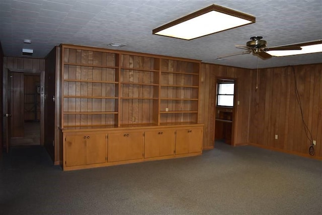 1668 2nd St, Lutcher, LA 70071 - unfurnished living room featuring carpet flooring, a textured ceiling, ceiling fan, and wood walls