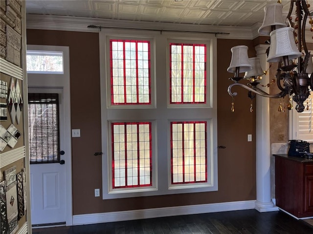 interior space with crown molding, dark wood-type flooring, and an inviting chandelier