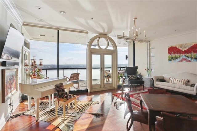 sunroom with a water view and an inviting chandelier