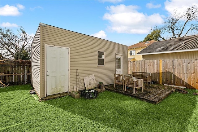 rear view of property featuring a yard and a storage unit