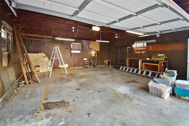 garage featuring a garage door opener and wood walls