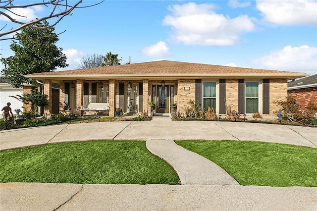 ranch-style home featuring a front lawn, a porch, and brick siding