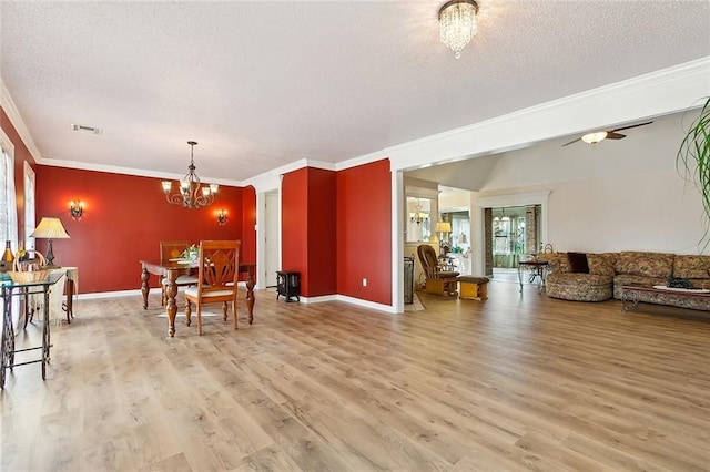 dining area with crown molding, ceiling fan with notable chandelier, a textured ceiling, and light hardwood / wood-style flooring