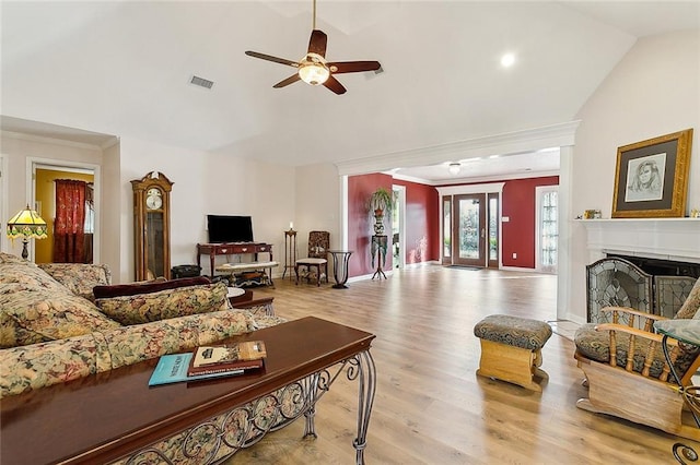 living room featuring crown molding, ceiling fan, light hardwood / wood-style floors, and vaulted ceiling