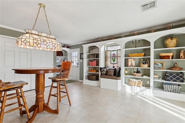 dining room featuring crown molding, light tile patterned flooring, built in shelves, and a textured ceiling