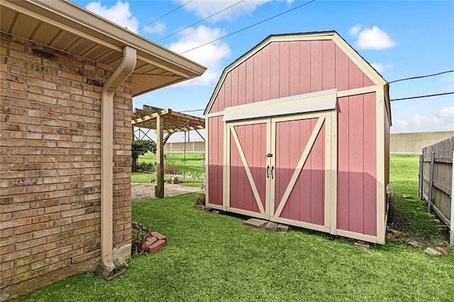 view of outdoor structure featuring a pergola and a lawn