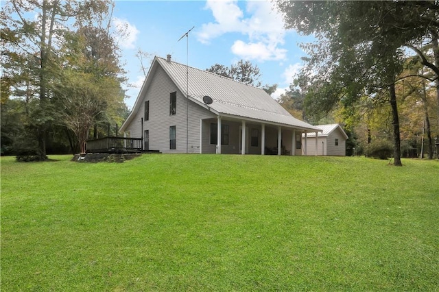 back of property featuring a wooden deck and a yard