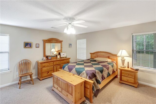 carpeted bedroom with multiple windows and ceiling fan