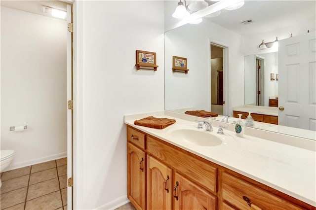 bathroom with vanity, tile patterned floors, and toilet