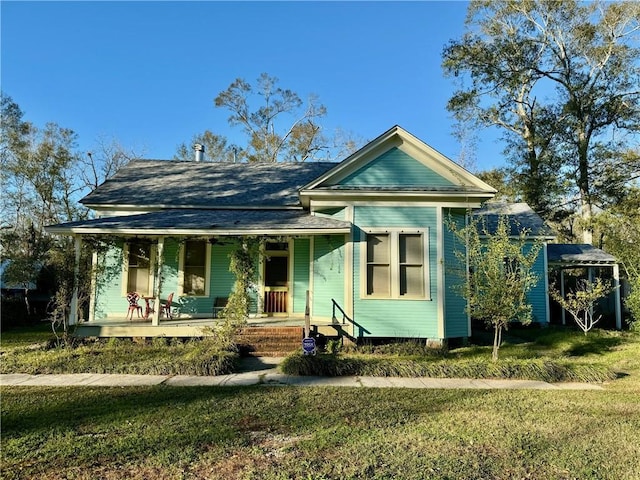 view of front of house with covered porch and a front lawn