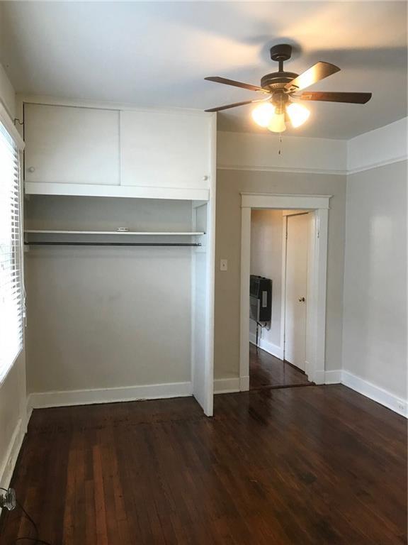 empty room with ceiling fan, dark hardwood / wood-style floors, and a healthy amount of sunlight