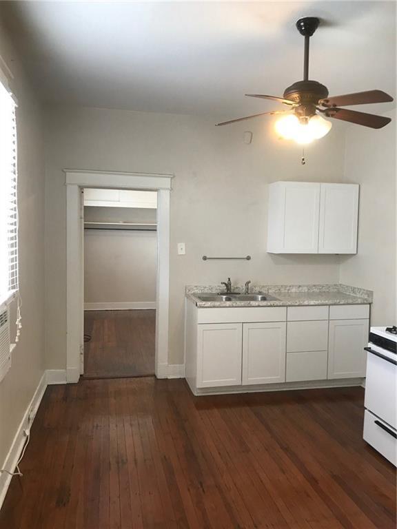 kitchen with white cabinetry, white electric range, dark wood-type flooring, and sink