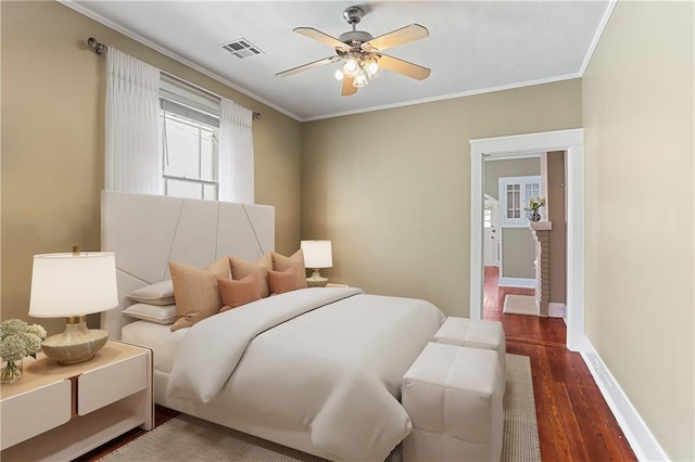 bedroom with ornamental molding, dark hardwood / wood-style floors, and ceiling fan