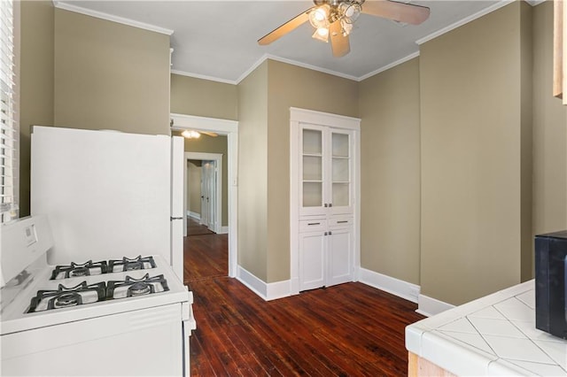 kitchen with ornamental molding, wood-type flooring, tile counters, and gas range gas stove