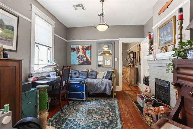 living area with dark hardwood / wood-style flooring and a brick fireplace