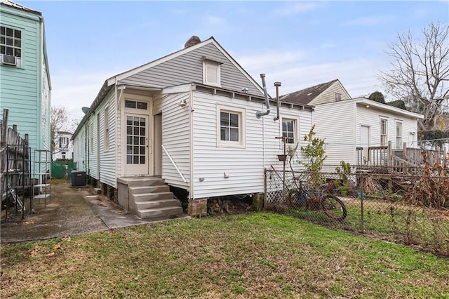 back of property featuring a lawn, a patio, and central air condition unit