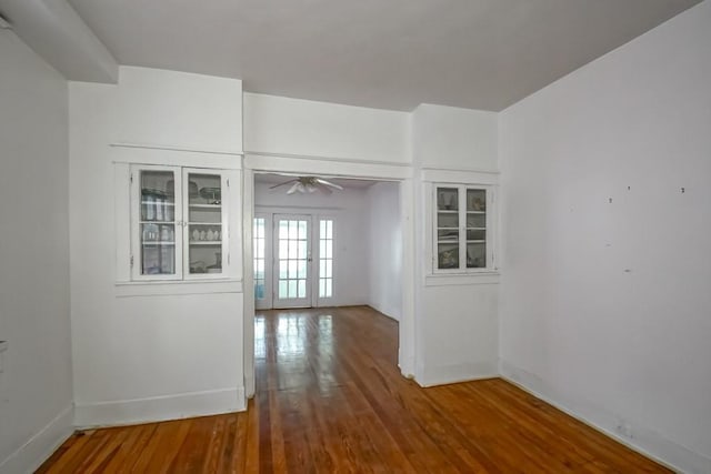 spare room with hardwood / wood-style floors, ceiling fan, and french doors