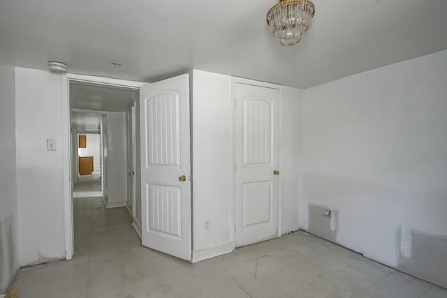 unfurnished bedroom featuring a chandelier