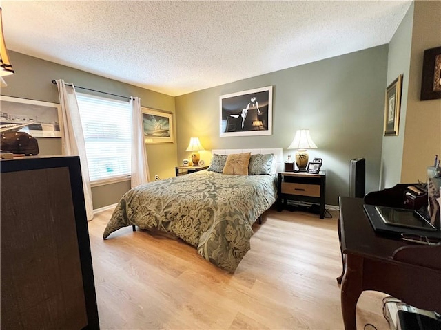 bedroom with light hardwood / wood-style floors and a textured ceiling