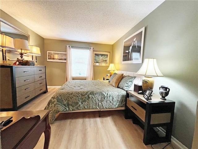 bedroom featuring a textured ceiling and light wood-type flooring