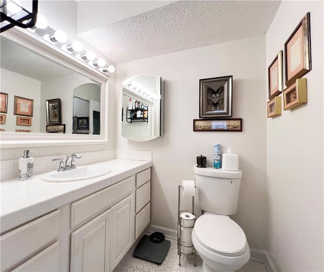 bathroom with vanity, a textured ceiling, and toilet