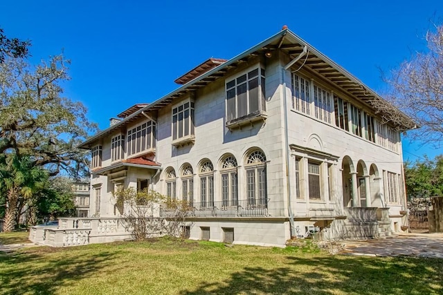 view of side of home featuring a yard and a patio area