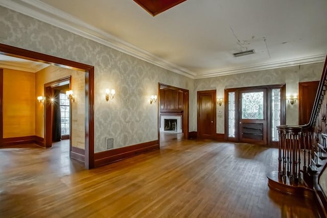 unfurnished living room featuring crown molding and hardwood / wood-style floors