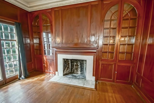 unfurnished living room with ornamental molding, wood-type flooring, and plenty of natural light