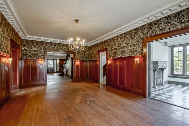 interior space featuring hardwood / wood-style flooring, crown molding, and an inviting chandelier