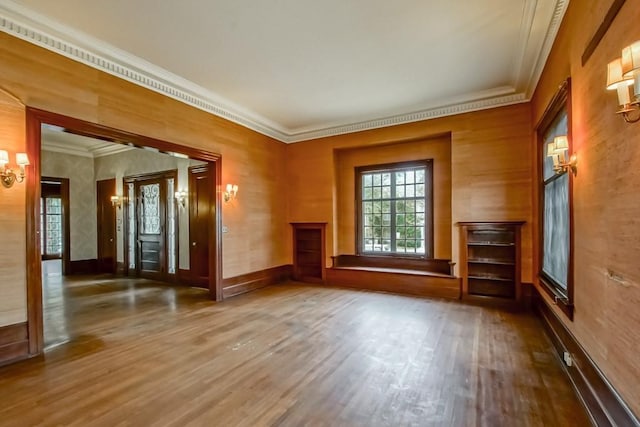 empty room featuring wood-type flooring and ornamental molding