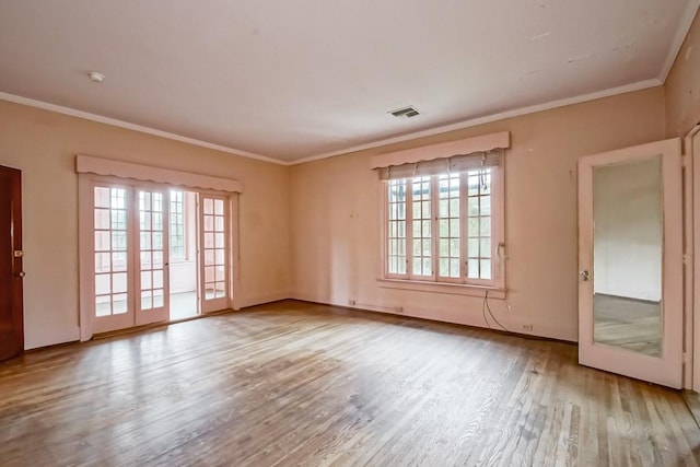 spare room with ornamental molding and light hardwood / wood-style flooring