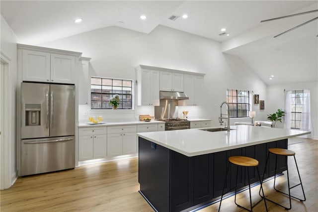 kitchen featuring sink, appliances with stainless steel finishes, a kitchen island with sink, light hardwood / wood-style floors, and white cabinets