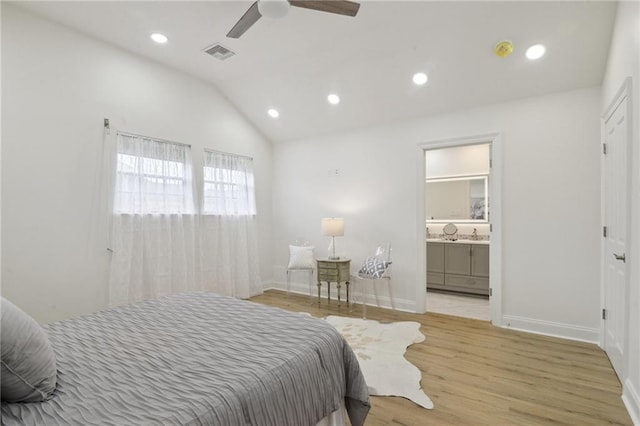 bedroom with lofted ceiling, connected bathroom, ceiling fan, and light hardwood / wood-style flooring