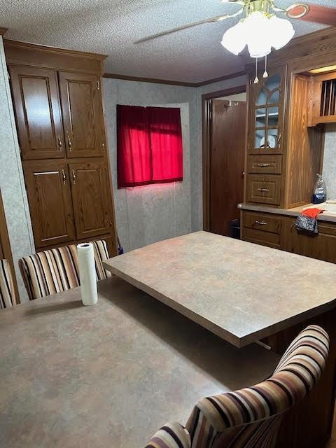 interior space featuring ornamental molding, a textured ceiling, and a breakfast bar area