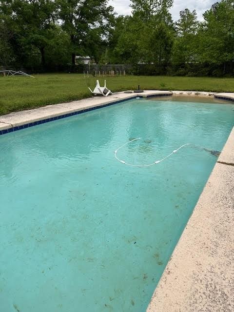 view of swimming pool with a lawn