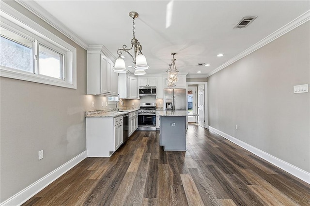 kitchen with a kitchen island, pendant lighting, white cabinetry, sink, and stainless steel appliances