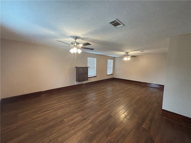 unfurnished living room with ceiling fan, a textured ceiling, and dark hardwood / wood-style flooring