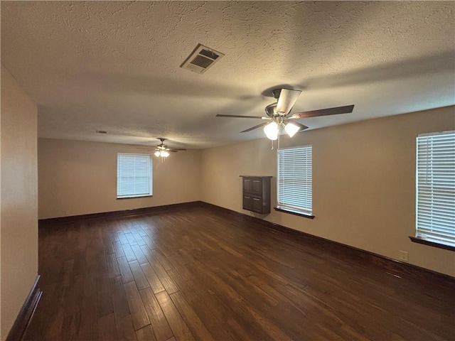 unfurnished room featuring ceiling fan, dark hardwood / wood-style flooring, and a textured ceiling