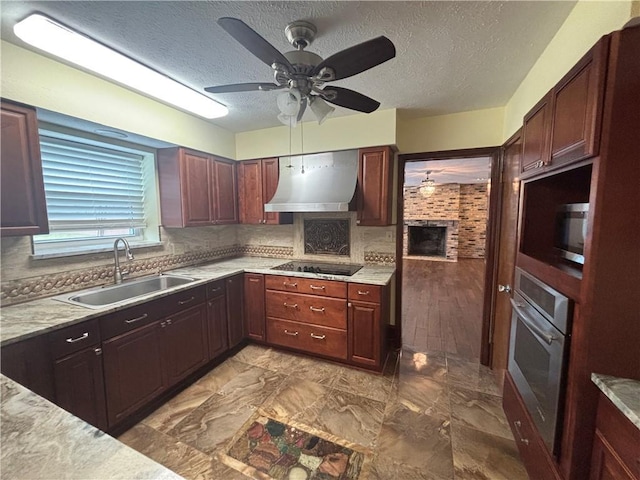 kitchen featuring tasteful backsplash, appliances with stainless steel finishes, sink, and wall chimney range hood