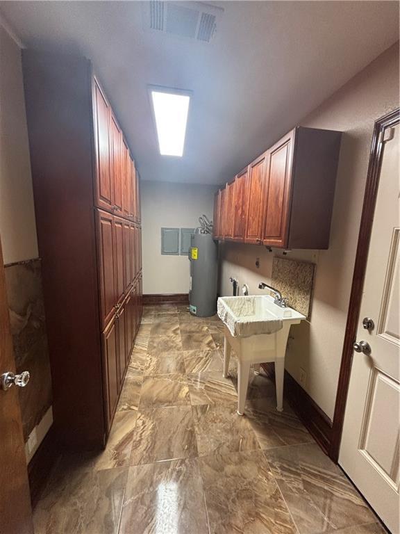 clothes washing area featuring cabinets, hookup for a washing machine, electric water heater, and sink