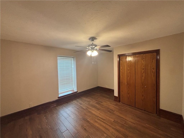 unfurnished bedroom featuring ceiling fan, dark wood-type flooring, a textured ceiling, and a closet