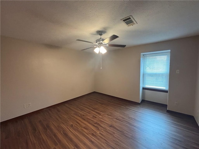 empty room featuring ceiling fan, a textured ceiling, and dark hardwood / wood-style flooring