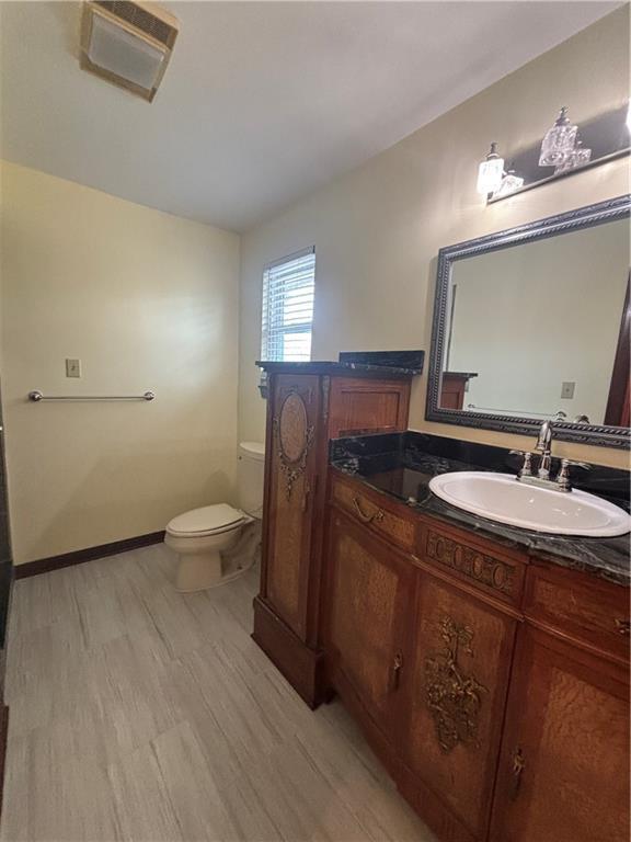 bathroom featuring vanity, hardwood / wood-style flooring, and toilet